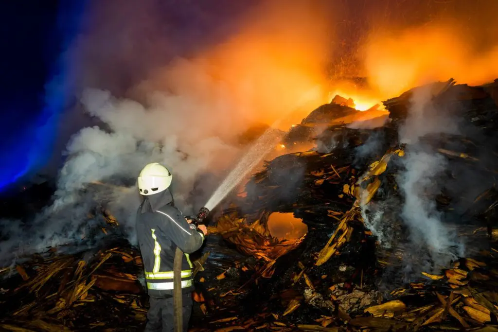 A Fire Damaged Site With Water Sprinkles