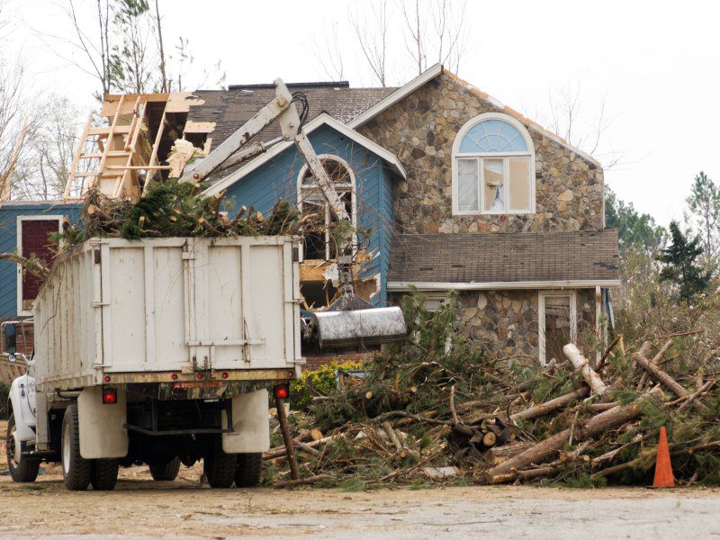 Tree service truck and crew cleaning up after a tornado