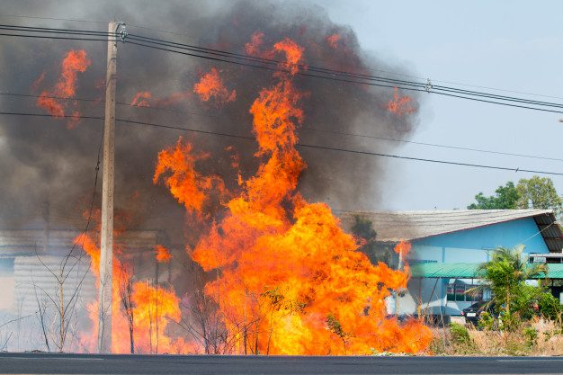 danger-fire-roadside-trees-electric-wires-many-black-smoke-floating-sky_51530-963